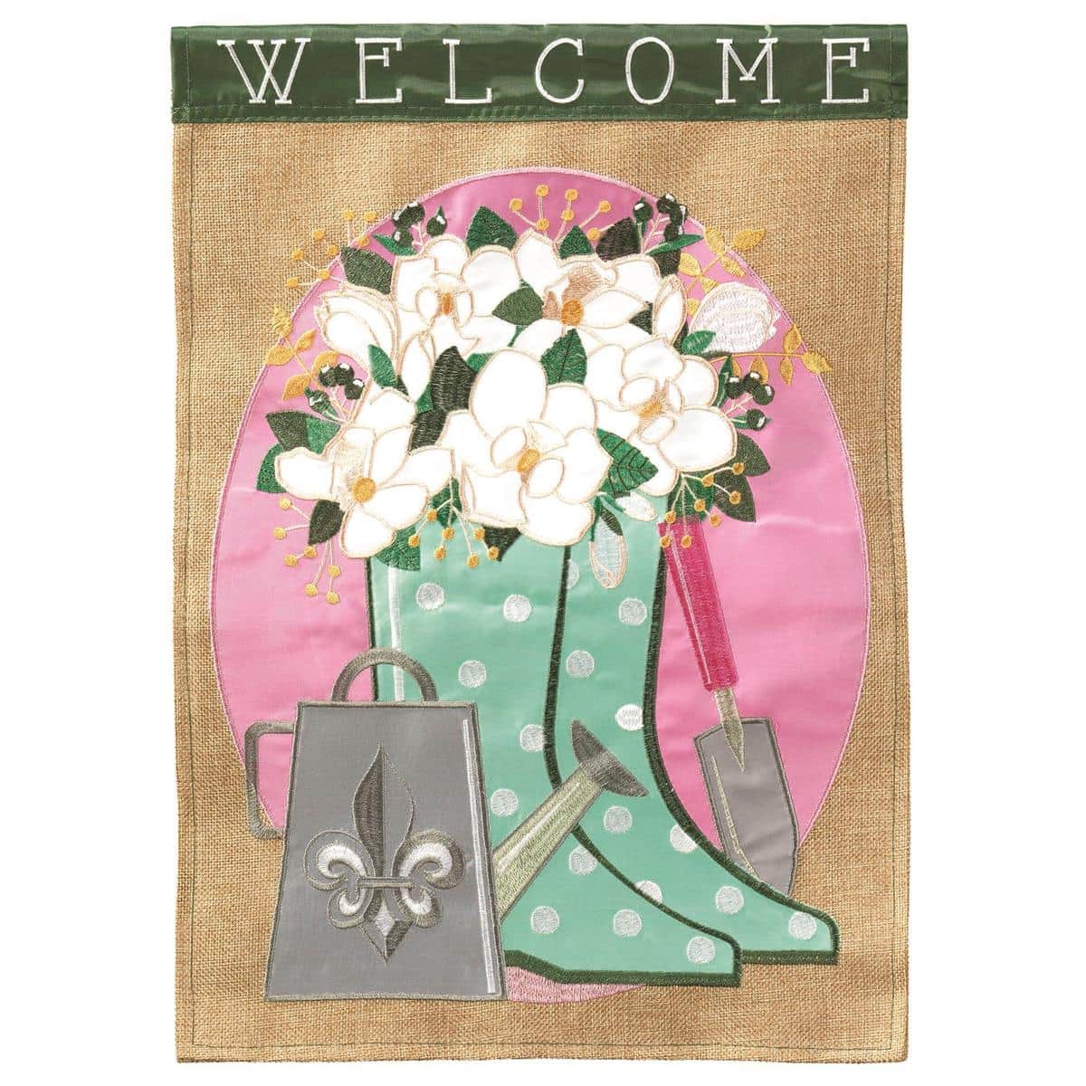 Double-sided 13x18 Welcome flag showing fleur-de-lis adorned boots with stitched applique, hanging on a garden stand by a front walkway in bright daylight.