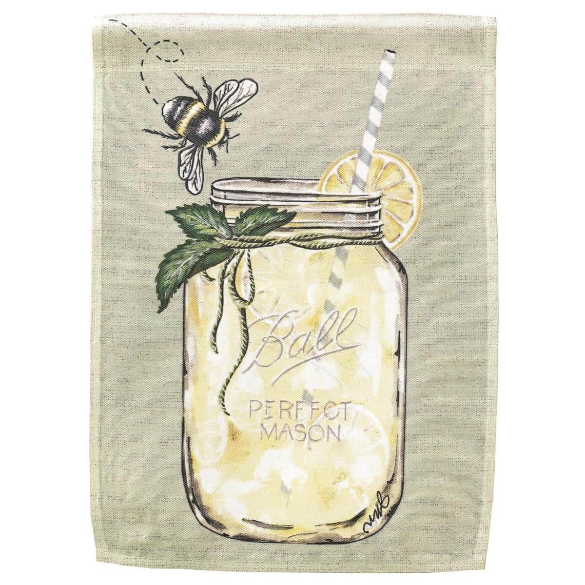 Close-up image of a 13x18 When Life Gives You Lemons printed garden flag showing bright lemon illustrations, green leaves, and playful script text hung on a standard garden flag pole in a sunny yard.
