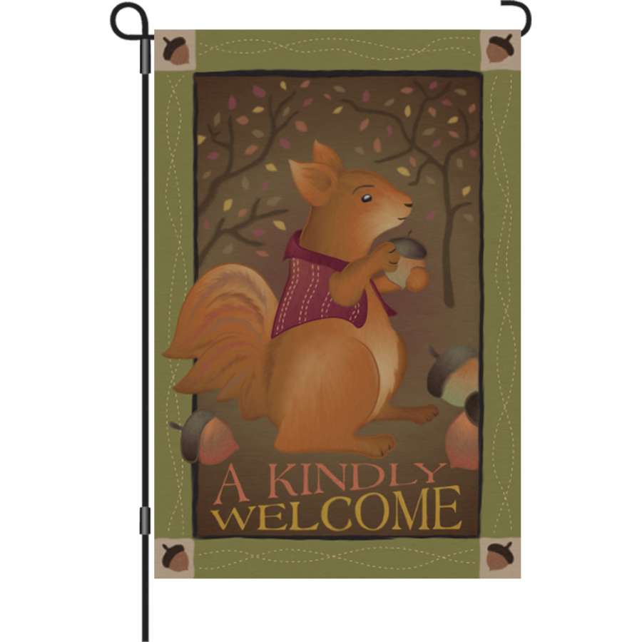 A Kindly Welcome garden flag, measuring 12 inches, featuring a vibrant autumn design displayed on a flag stand in an outdoor setting.