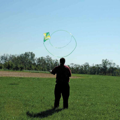 Green Ace Sport Kite flying in the sky, showcasing loops and stunts with a long tail, perfect for outdoor enthusiasts.