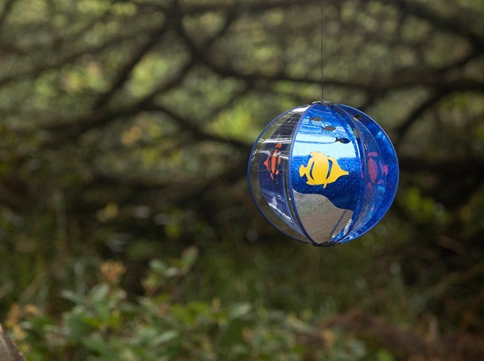 Aqua Dream Spinning Globe featuring six colorful poly panels, spinning in the sunlight, creating a mesmerizing garden decoration.