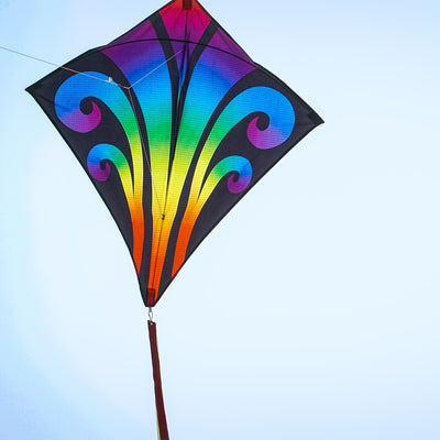 Aurora 30-inch diamond kite featuring vibrant colors and tails, soaring against a clear blue sky, captured in a fun outdoor setting.
