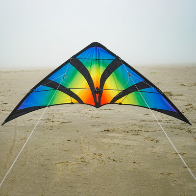 Aurora 48 inch Stunt Kite featuring a brilliant aurora pattern, flying against a clear blue sky in a festive outdoor setting.
