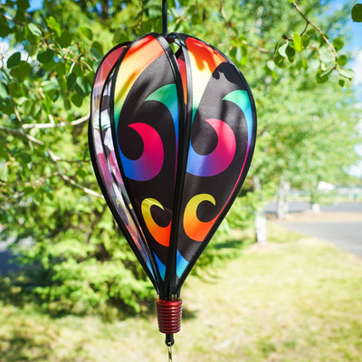 Aurora 6-Panel Hot Air Balloon in vibrant rainbow colors, displayed in a garden setting, spinning gracefully with colorful tail.