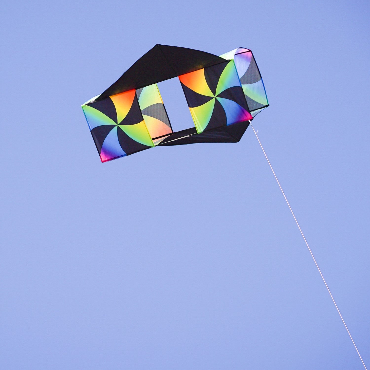 Aurora Winged Double Box Kite soaring high with its vibrant wings against a clear blue sky, showcasing its colorful design during flight.