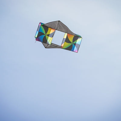 Aurora Winged Double Box Kite soaring high with its vibrant wings against a clear blue sky, showcasing its colorful design during flight.