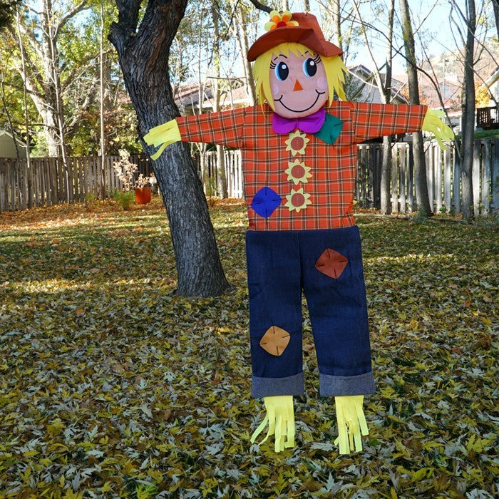 Autumn Scarecrow Wind Friend staged outdoors in a garden setting, perfect for enhancing fall decor.
