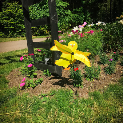 Baby Chick Whirligig featuring a cute yellow chick design spinning in the breeze in a garden setting, crafted from durable materials.