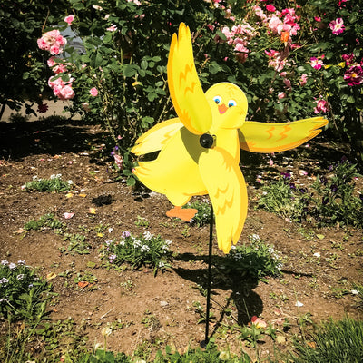 Baby Chick Whirligig featuring a cute yellow chick design spinning in the breeze in a garden setting, crafted from durable materials.