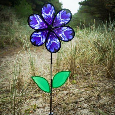 Vibrant 13.5-inch Bachelor Button Spinner with realistic blue flower and green leaves spinning on a fiberglass pole in a garden setting.