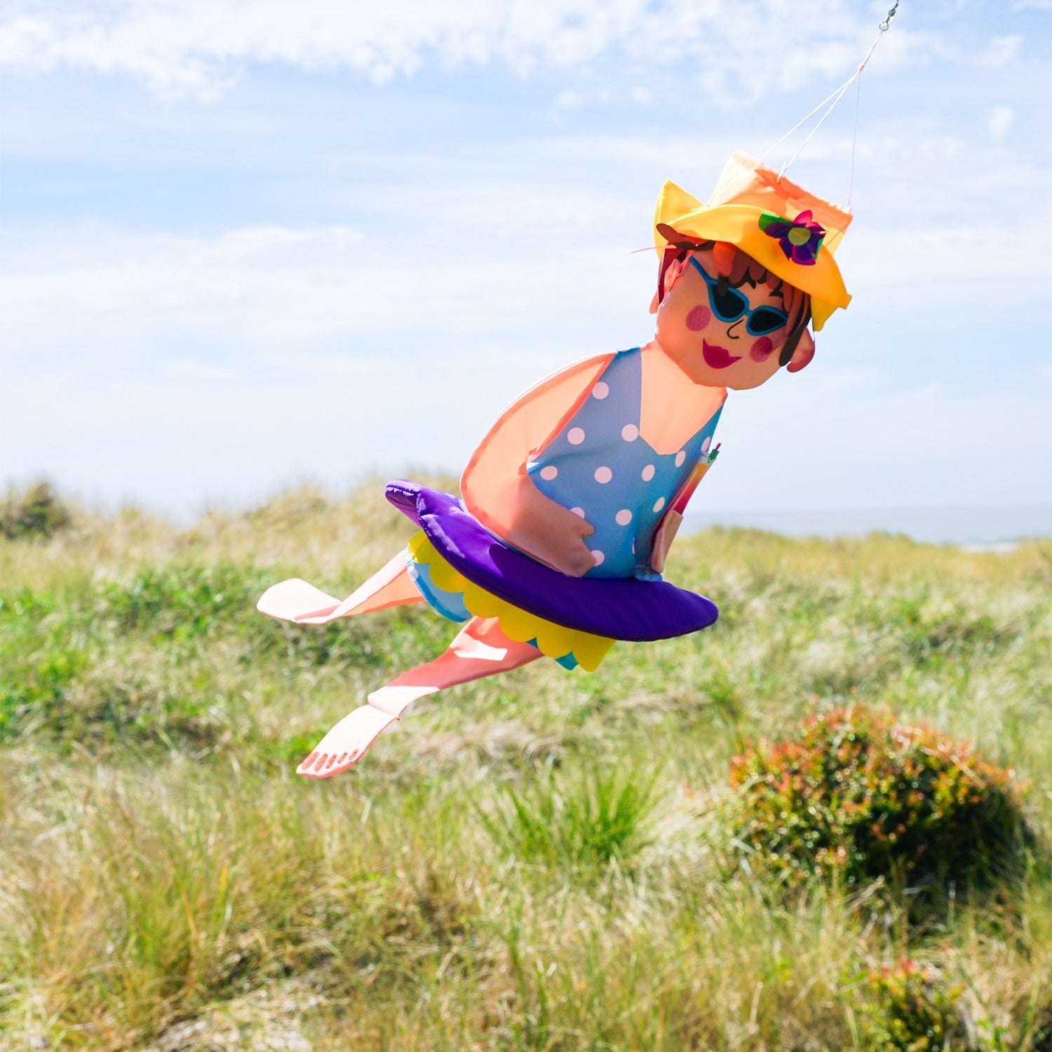 Beach Bev Wind Friend hanging decor featuring 3D design, vibrant colors, and embroidered accents, displayed outdoors in a garden setting.