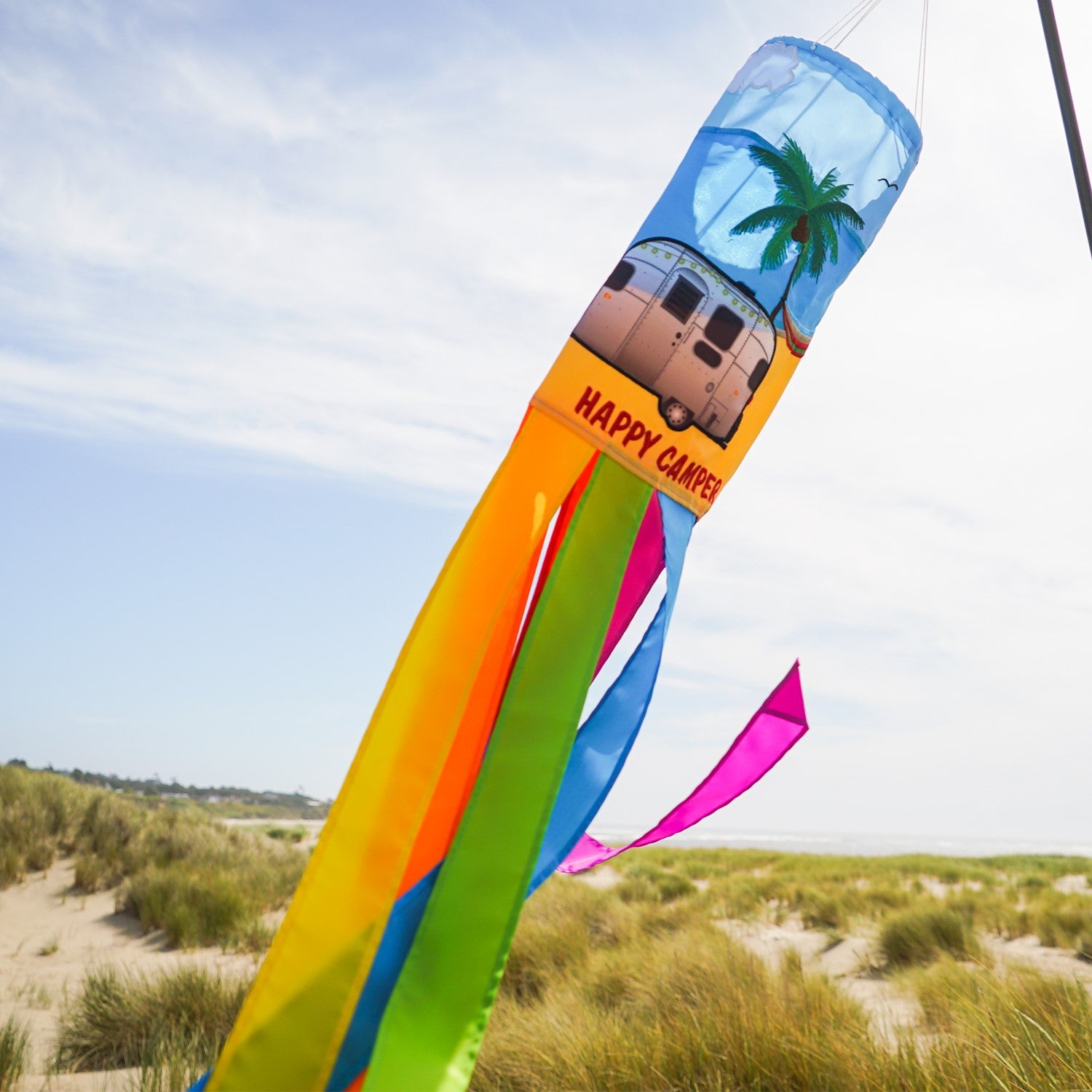 Colorful Beach Camping 40-inch Windsock featuring vibrant applique design hung outdoors, waving in the breeze above the ground.
