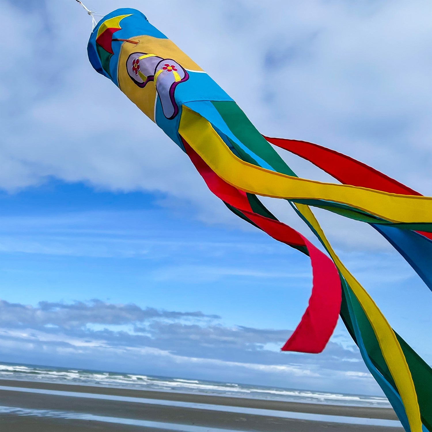 Colorful Beach Scene 40" Windsock with surfboards and whimsical tails on display, adding a coastal vibe to any outdoor setting.