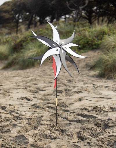 Black and White Spinning Jester with Rotating Windsail displayed in a garden, showcasing two 27-inch wheels and a fun design spinning in the wind.