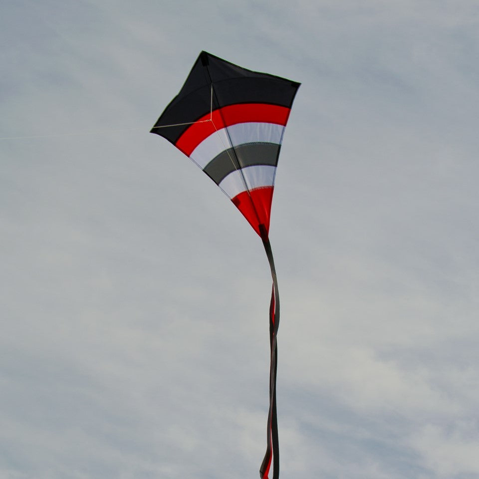 Blazer Arch 27" Diamond Kite with colorful arcs displayed against a blue sky, showcasing its vibrant design and tails.