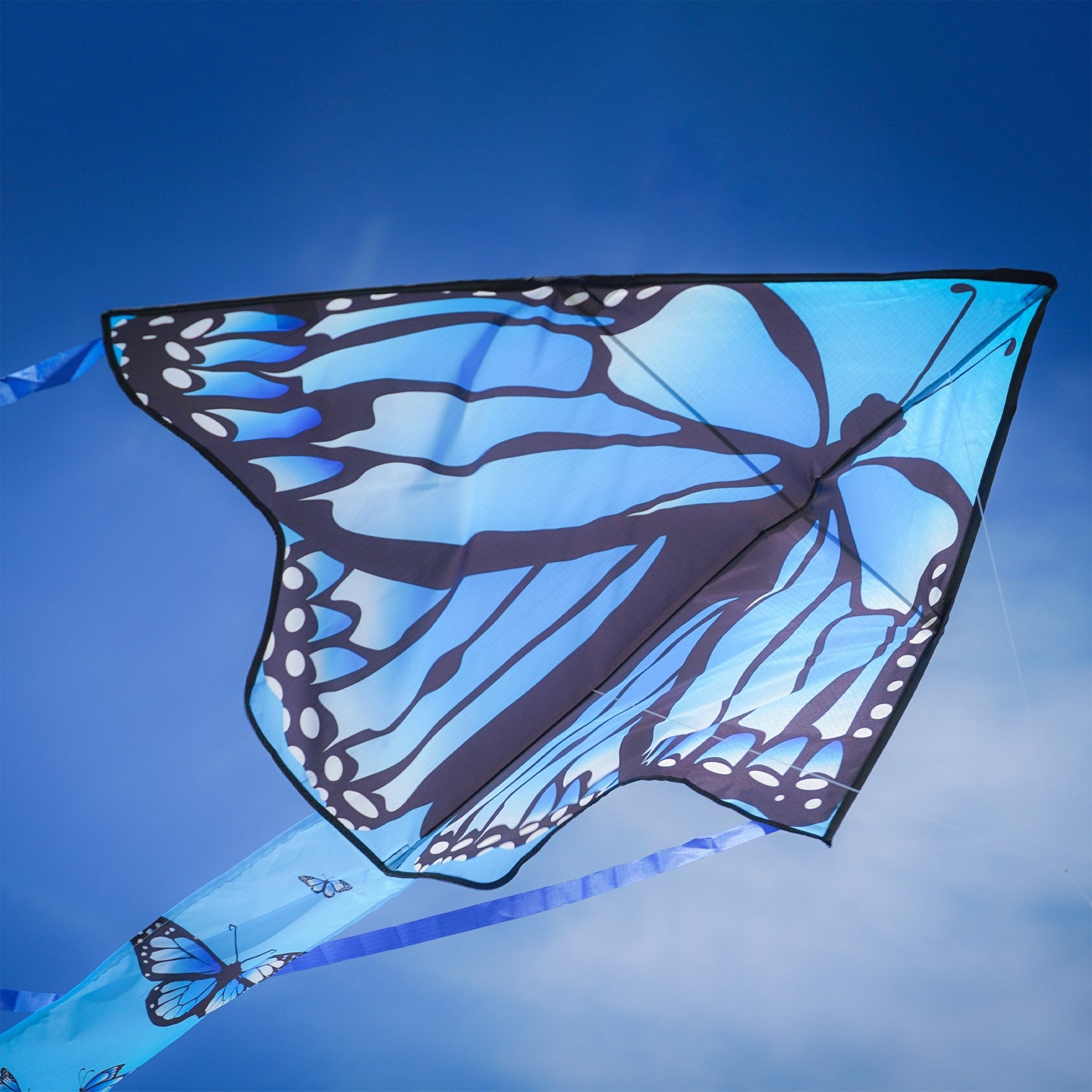 Blue Butterfly Swarm 45 inch Fly-Hi Kite soaring in the sky, showcasing a vibrant blue karner butterfly design with streamer tails.