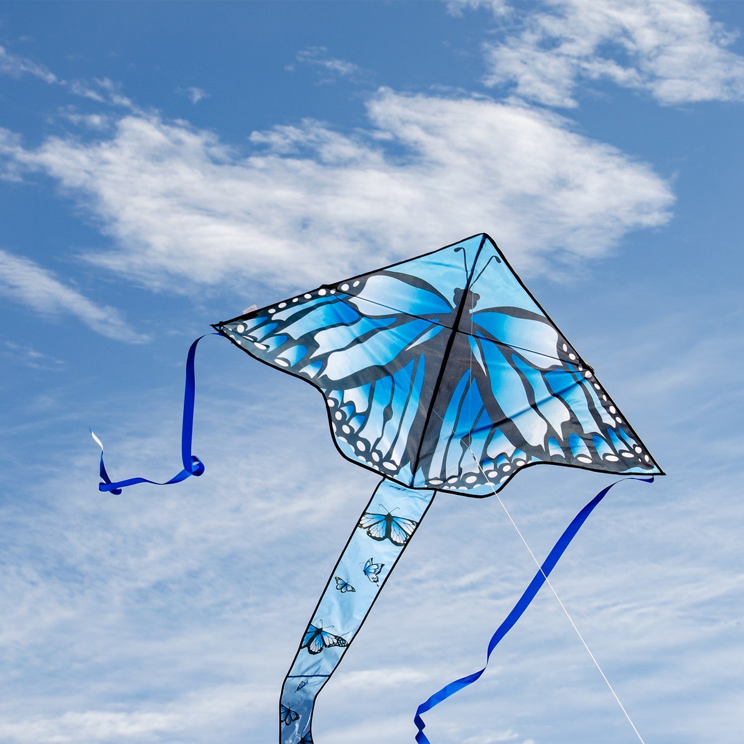 Blue Butterfly Swarm 45 inch Fly-Hi Kite soaring in the sky, showcasing a vibrant blue karner butterfly design with streamer tails.