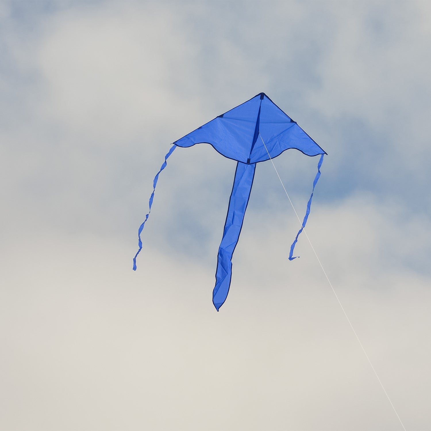 Blue Colorfly 43 inch Fly-Hi Kite soaring in the sky, featuring a solid blue design, crafted for easy flying and outdoor enjoyment.