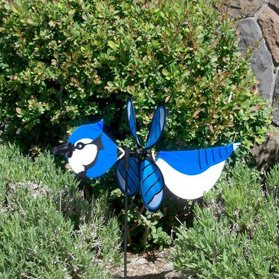 Blue Jay Baby Spinner vividly displayed in a garden setting, featuring colorful design and 12-inch spinning wheel for outdoor charm.