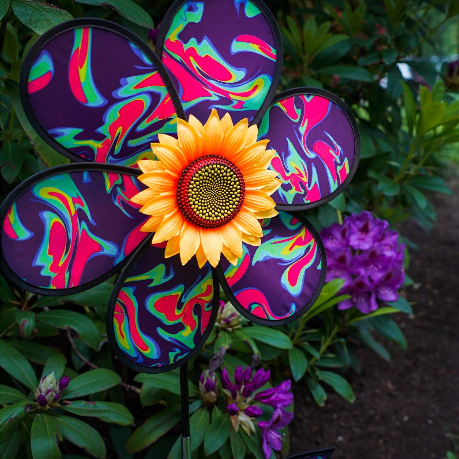 16 inch Blue Psychedelic Flower with Leaves garden spinner showcasing six petals, sunflower center, and leaves attached to a stand in a vibrant outdoor setting.