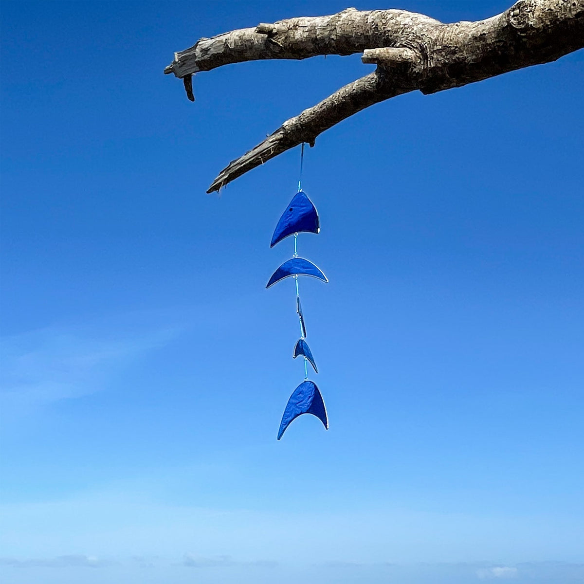 Blue Resin Fish Mobile featuring a blue gradient design, hanging decor with colored resin blocks, swaying gently in a sunlit outdoor setting.