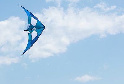 Blue/Teal Alpha + 3 kite with Dyneema lines in a clear sky, showcasing its ripstop nylon fabric and aerodynamic design.