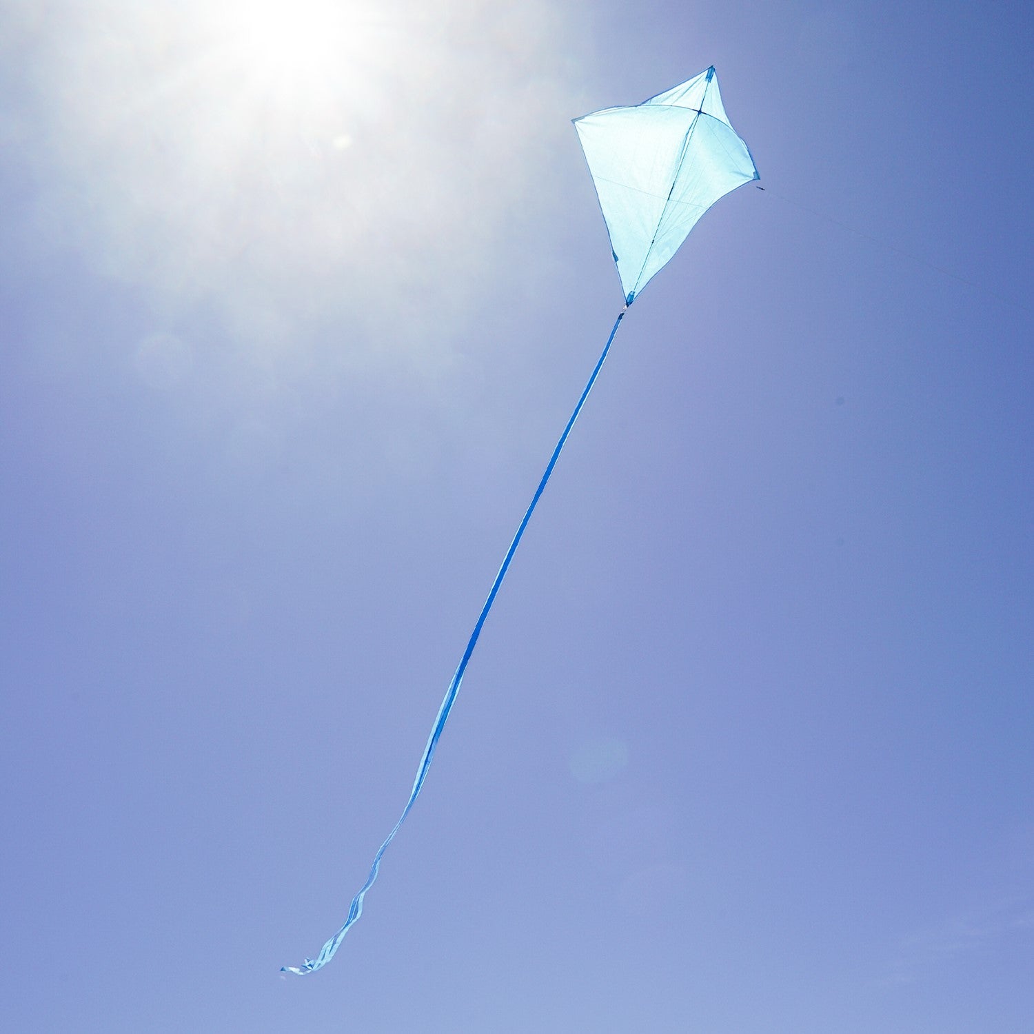 Blueberry 30'' Colorfly Diamond Kite flying high in a clear blue sky with three vibrant tails trailing behind.