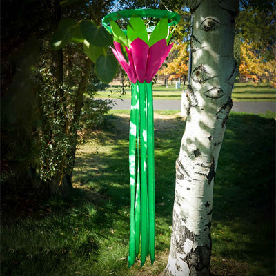 Bright Green 38 inch Lotus Flower Windsock with colorful petals and flowing green tails displayed in a garden setting under clear skies.