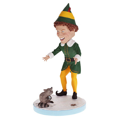 Buddy the Elf with Raccoon bobblehead standing on a shelf, showcasing vibrant colors and playful design, perfect for holiday decor.