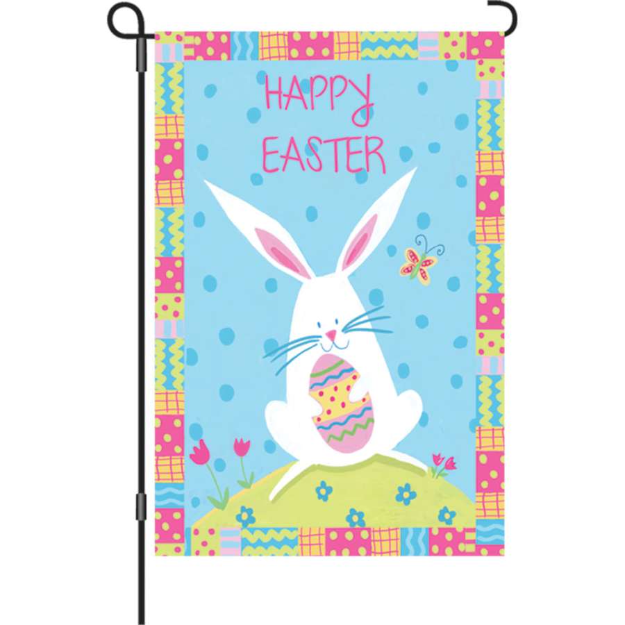 12 in. Bunny Easter garden flag made of PremierSoft fabric displaying the text 'HAPPY EASTER' in bright colors on an outdoor pole.