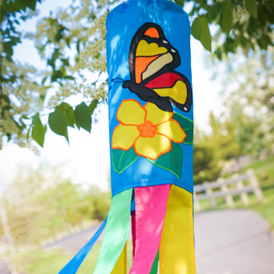 Butterfly 40-inch windsock with bright colors and detailed applique graphics hanging outdoors, fluttering in the breeze against a sunny backdrop.