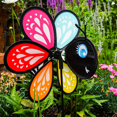 Colorful Butterfly Baby Spinner with baby butterfly design spinning on a garden pole, showcasing bright colors in a sunny outdoor setting.