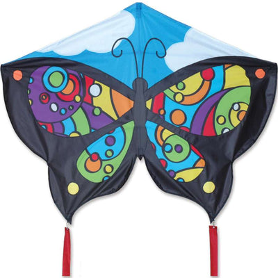 Butterfly Kite - Rainbow Orbit soaring in a clear sky, showcasing its vibrant butterfly design and ripstop polyester fabric against the sun.