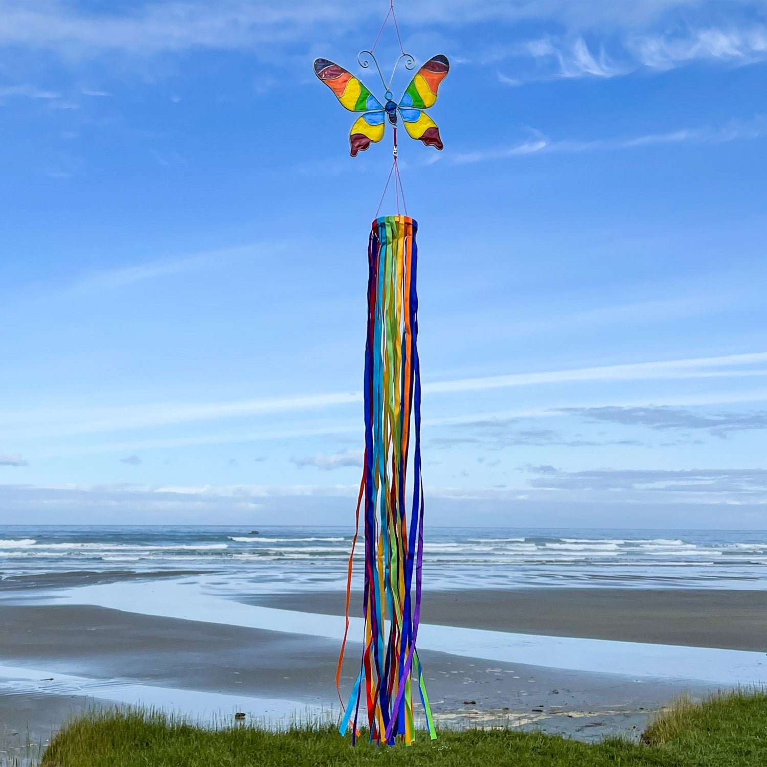 Butterfly & Ribbon Windsock featuring rainbow satin ribbons and a colorful resin butterfly, swaying gently in an outdoor setting.