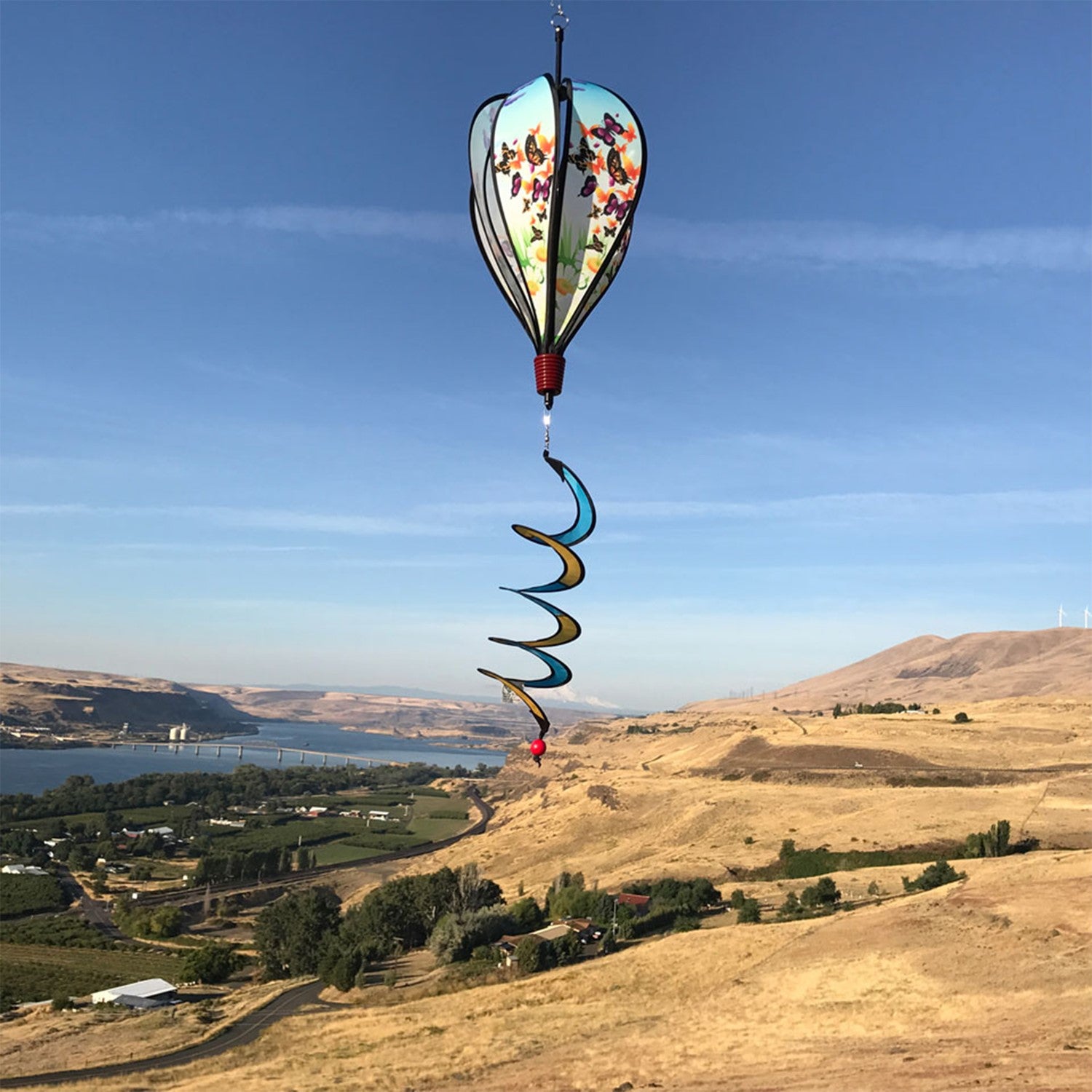 Butterfly Swarm Hot Air Balloon spinning in a garden, featuring colorful butterfly graphics and clear plastic mount for stability.