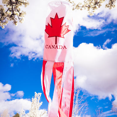 Canada 40 inch windsock with vibrant colors and detailed embroidered graphics fluttering outdoors in a garden setting.