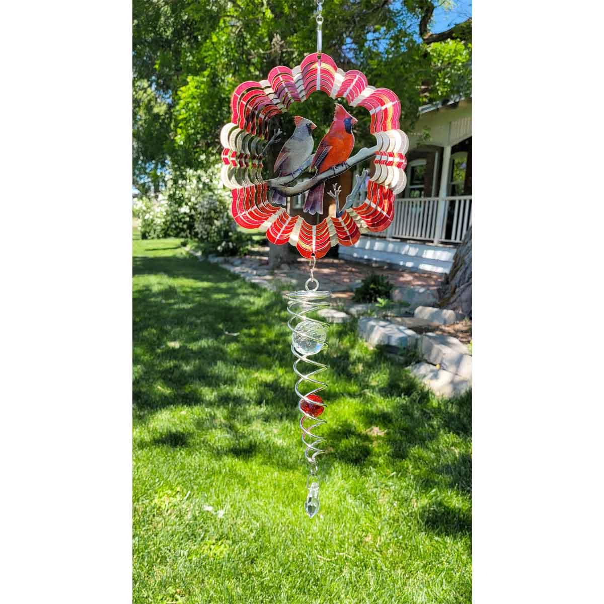 Vibrant Cardinals Mini Set Wind Spinners displayed in a garden, including a 6.5-inch wind spinner and a 7.5-inch crystal twister, shining in sunlight.