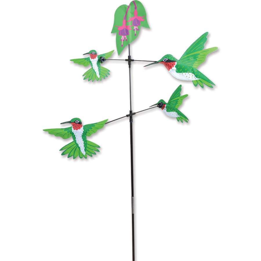 Carousel Spinner featuring Hummingbirds design rotating in the wind, showcasing vibrant colors and intricate shapes in an outdoor garden setting.