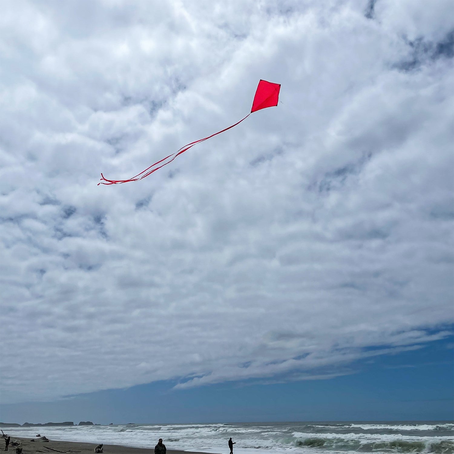 Cherry Colorfly 30-inch diamond kite with three color-coordinated tails flying in a blue sky, showcasing its vibrant solid color design.