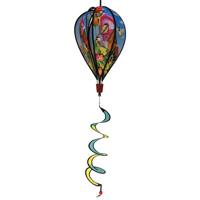 Chickadee Birdhouse Hot Air Balloon spinning in the breeze, showcasing vibrant chickadee graphics and a colorful curlie tail adorned from a wooden basket.