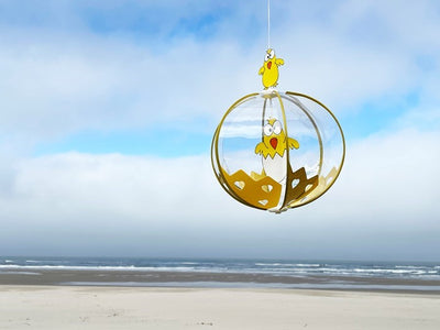 Chicks Spinning Globe wind fairy ornament with colorful baby chicks, spinning gracefully in a sunny outdoor setting.
