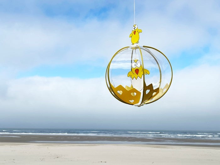 Chicks Spinning Globe wind fairy ornament with colorful baby chicks, spinning gracefully in a sunny outdoor setting.