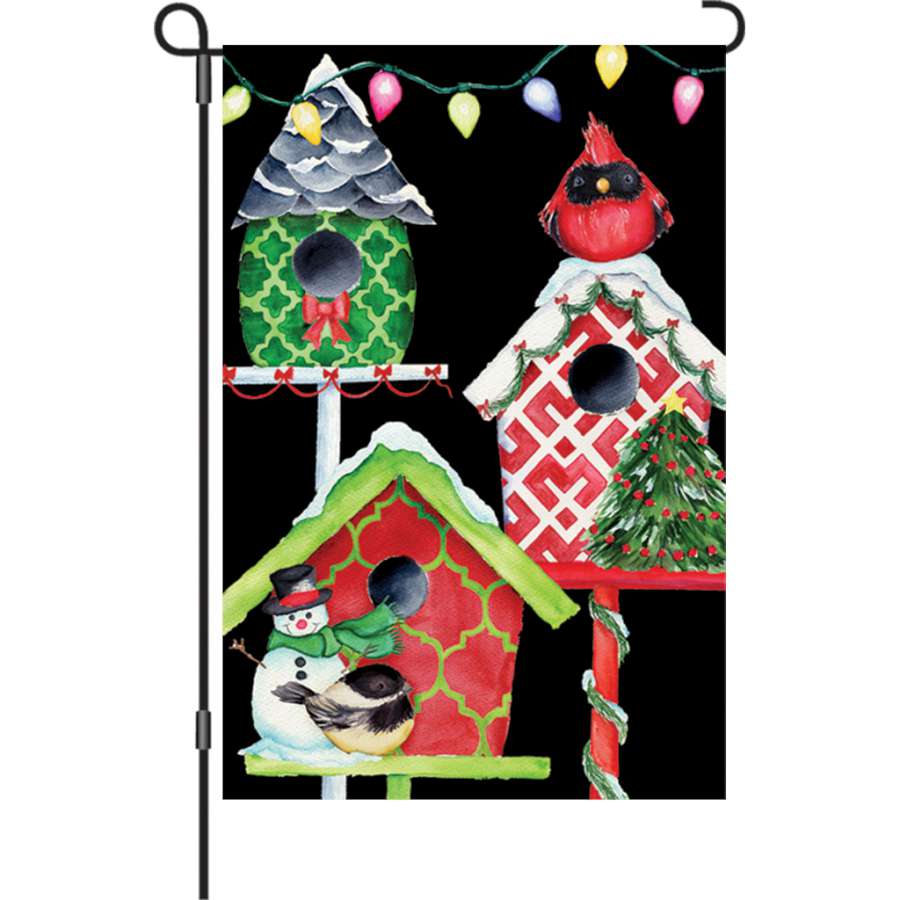 12 in. Christmas Birdhouses illuminated garden flag displayed outdoors, featuring vibrant birdhouse designs glowing in the evening light.