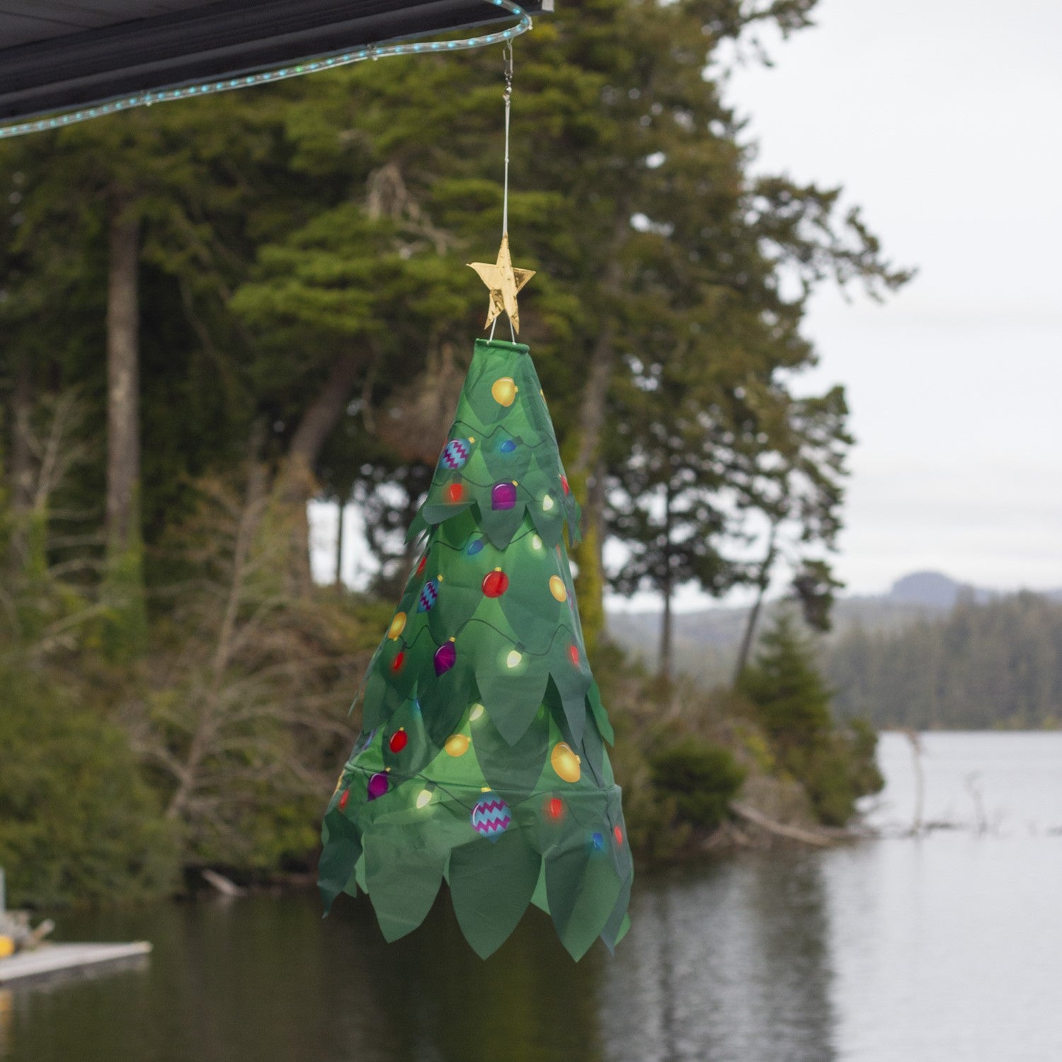 Colorful Christmas Tree 3D Windsock with a golden star displayed outdoors, showcasing vibrant colors that catch the breeze beautifully.