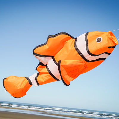Clownfish Big Breeze WindsockTM, a vibrant 3D windsock with a detailed clownfish design, displayed in a garden setting swaying in the breeze.