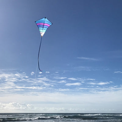 Cool Arch 27' Diamond Kite in vibrant rainbow colors flying high in a clear sky, ideal for beach and park activities.