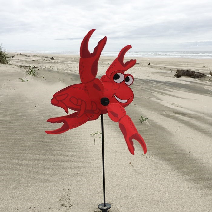 Crab Baby Whirligig garden decoration with vibrant crab design featuring spinning claws, displayed outdoors in a garden setting.