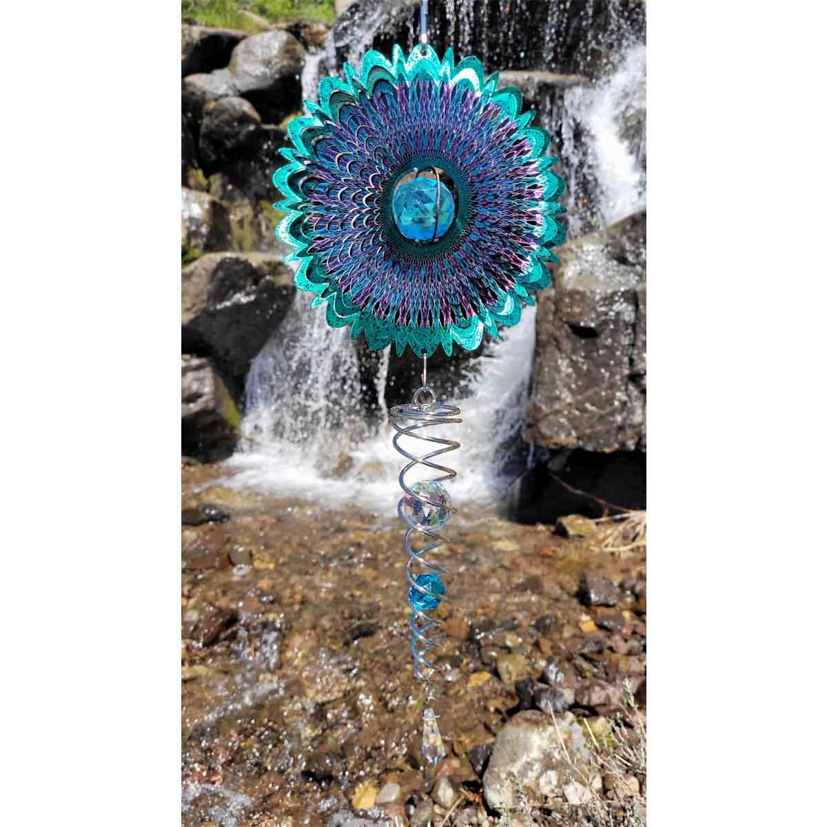 Crystal Cosmic Mandala 6.5-inch wind spinner with sparkly center and twister, visually captivating in an outdoor garden setting.