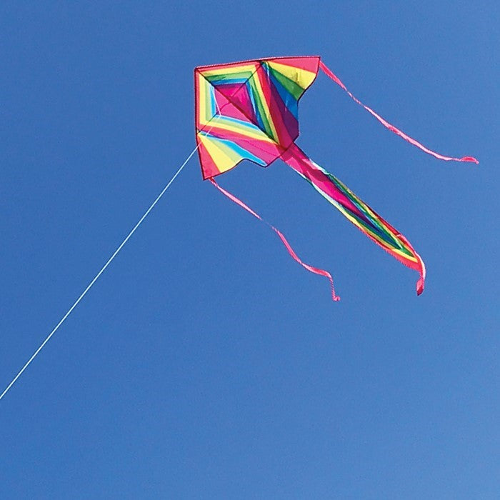 Dayglow 45-inch Fly-Hi Kite in bright rainbow colors flying high against a clear sky with two colorful streamer tails.