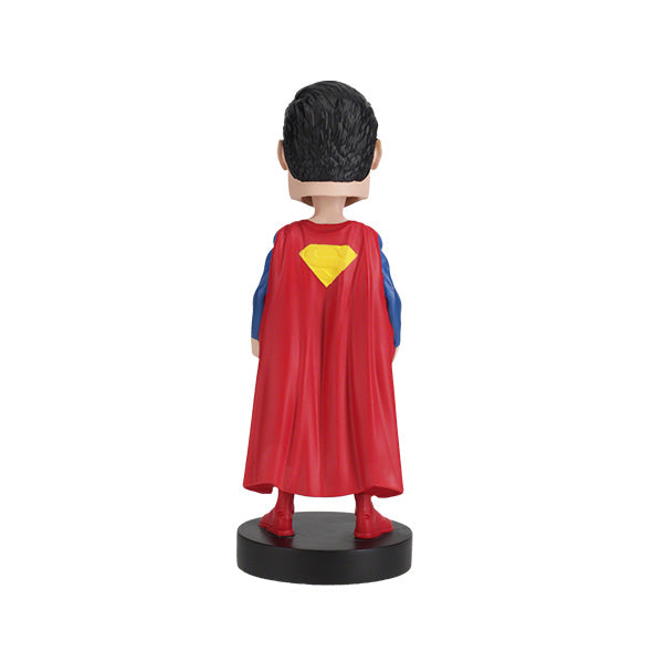 DC Comics Superman 6-inch bobblehead featuring Superman in his Rebirth suit with a vibrant red cape, placed on a display shelf.